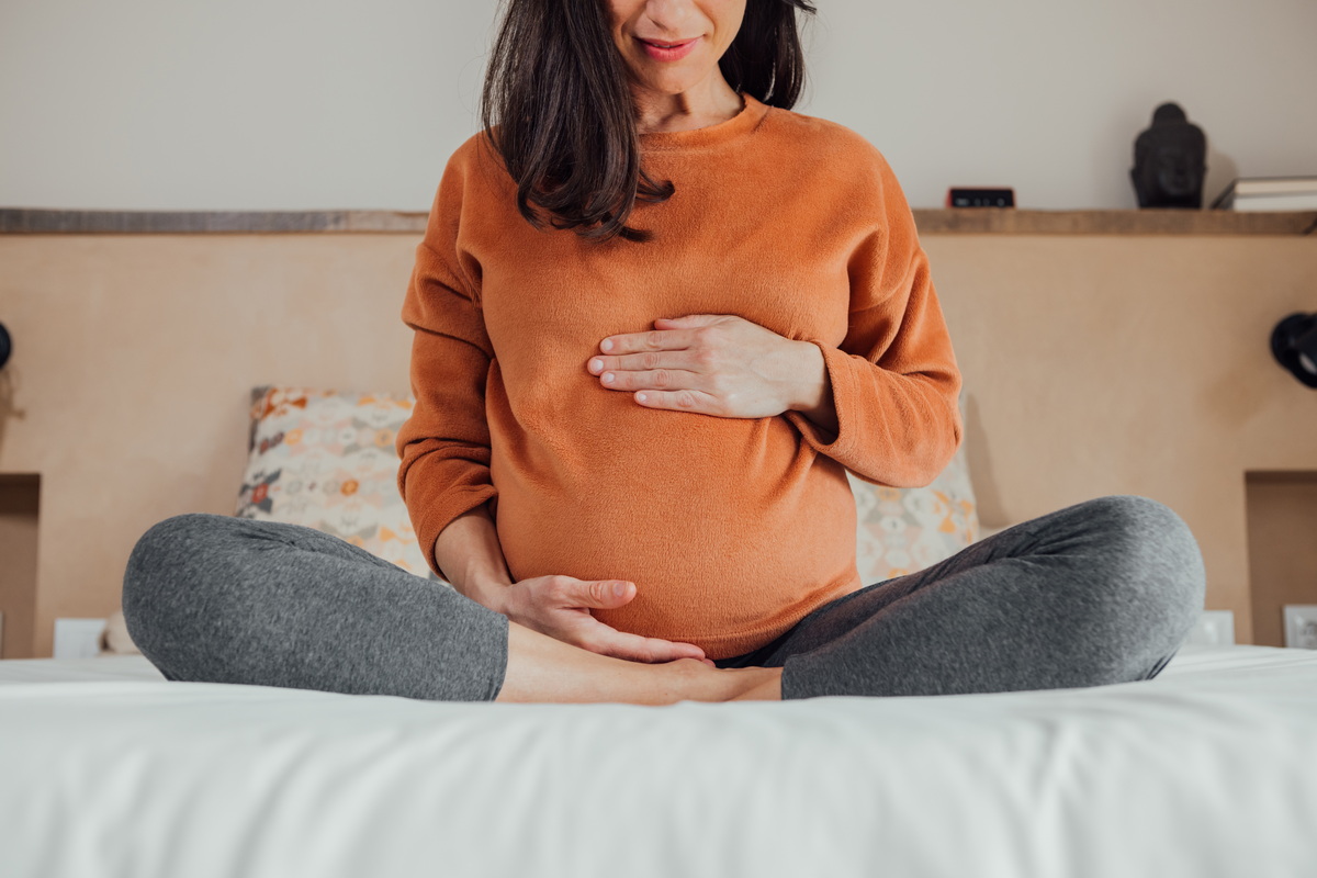 Femme enceinte touche son ventre.